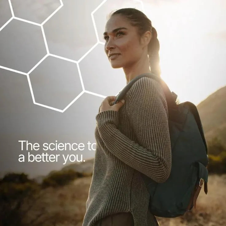 A woman with a backpack smiles outdoors - the science to a better you